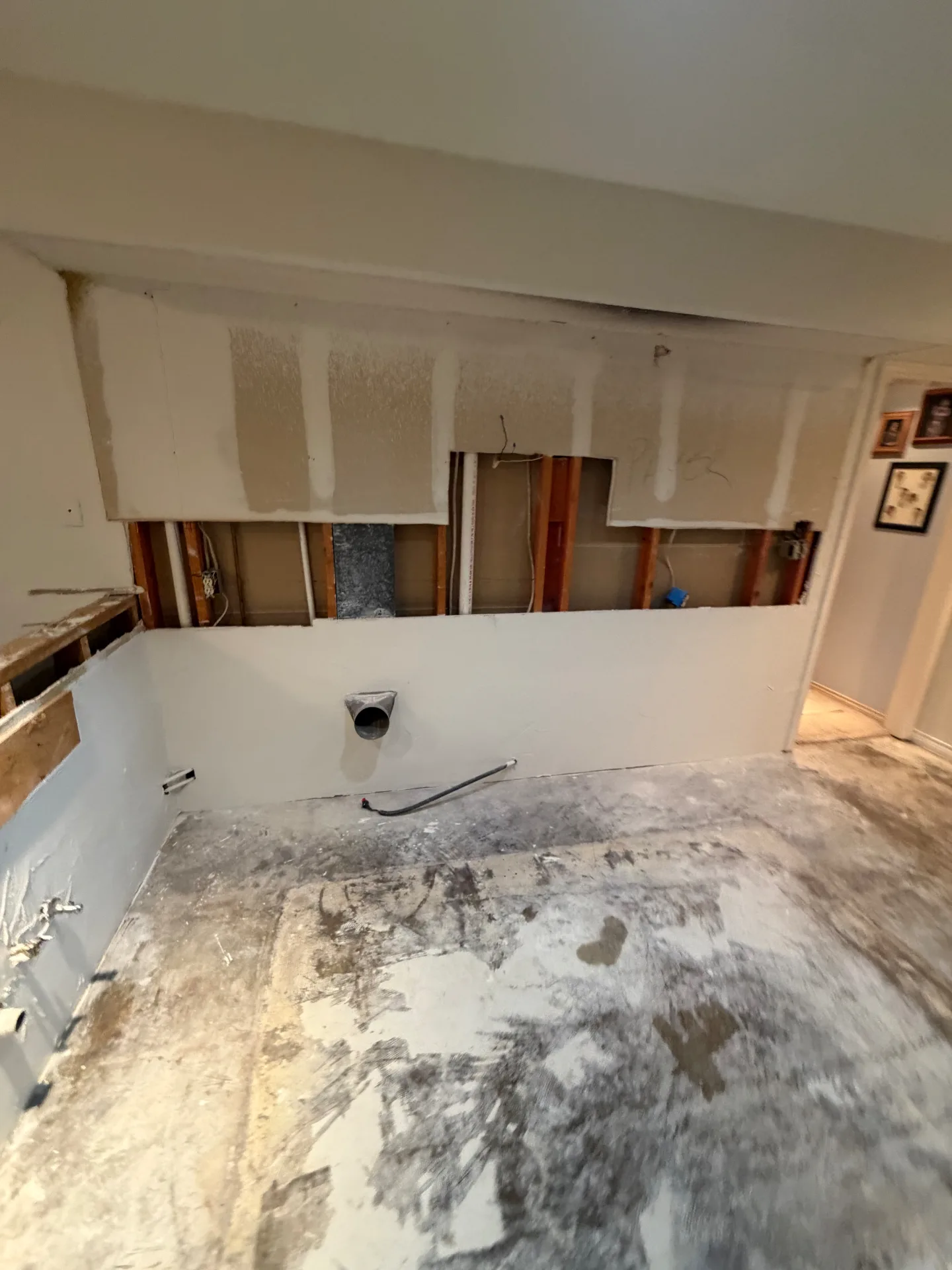 Full kitchen demolition with cabinets, countertops, and walls removed to the studs