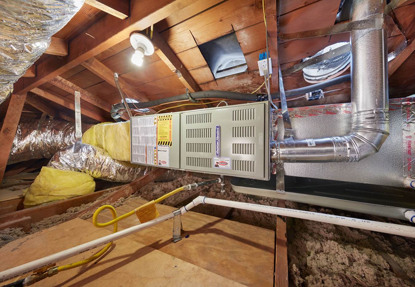 Gas furnace installed in an attic before removal
