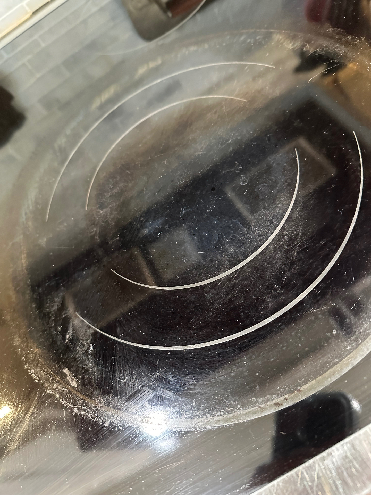 Damaged electric glass cooktop with deep scratches before removal