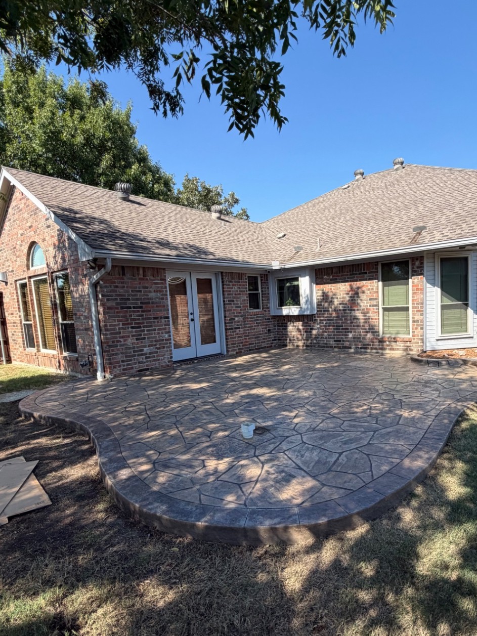 Same view of the Lewisville home with the pergola fully removed and the stamped concrete patio cleared