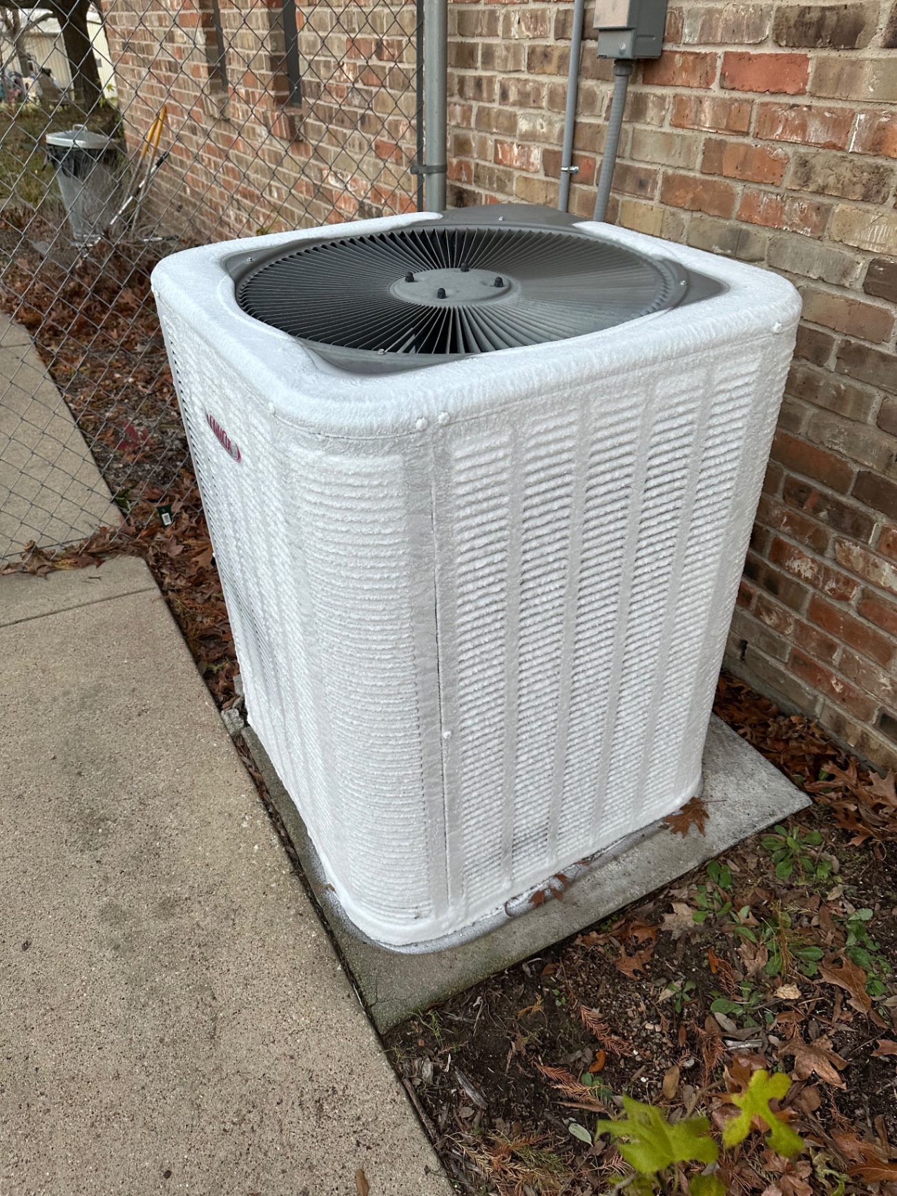 Failed outdoor air-conditioning condenser frozen over before removal