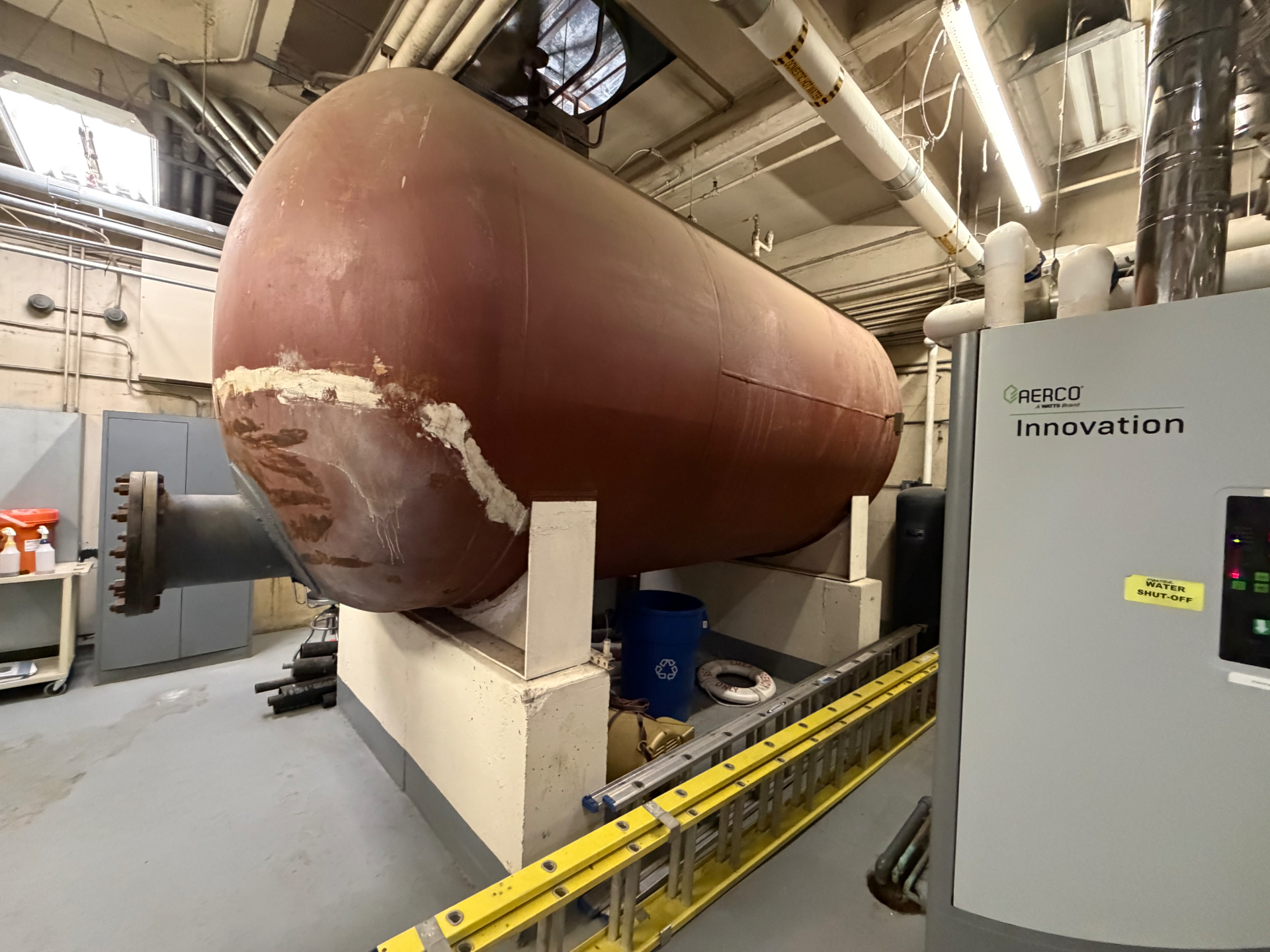 Massive commercial water-heating tank inside a mechanical room with restricted access