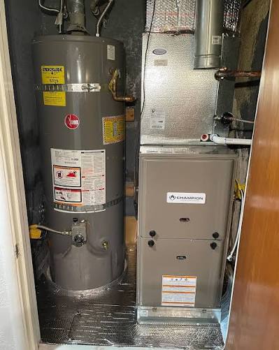 Gas furnace installed next to a water heater in a home utility closet