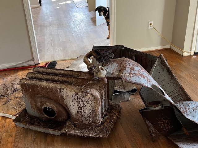 Old cast-iron floor furnace removed from a home before haul-away