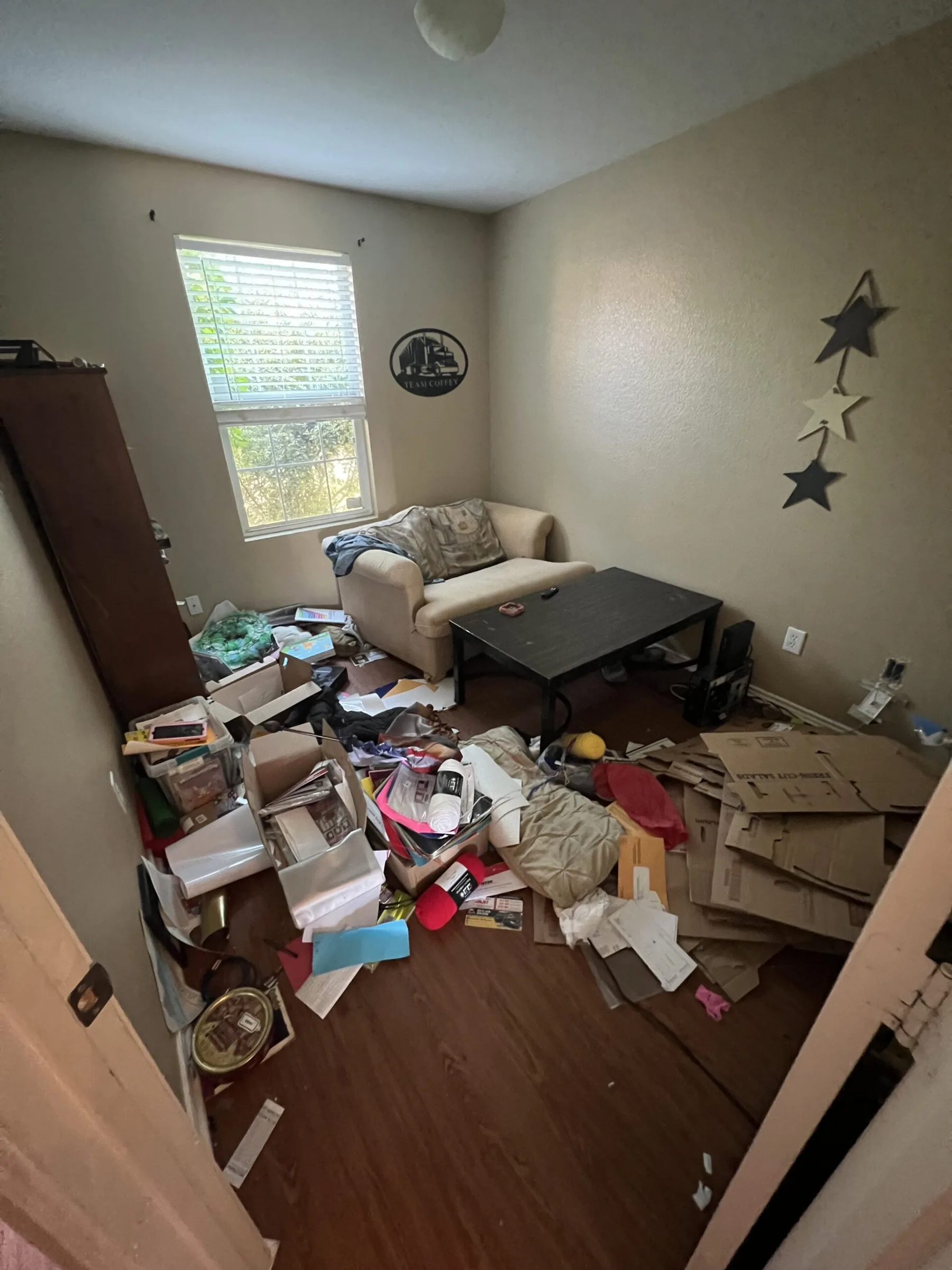 Living room full of belongings left behind before an eviction cleanout in Forney, TX