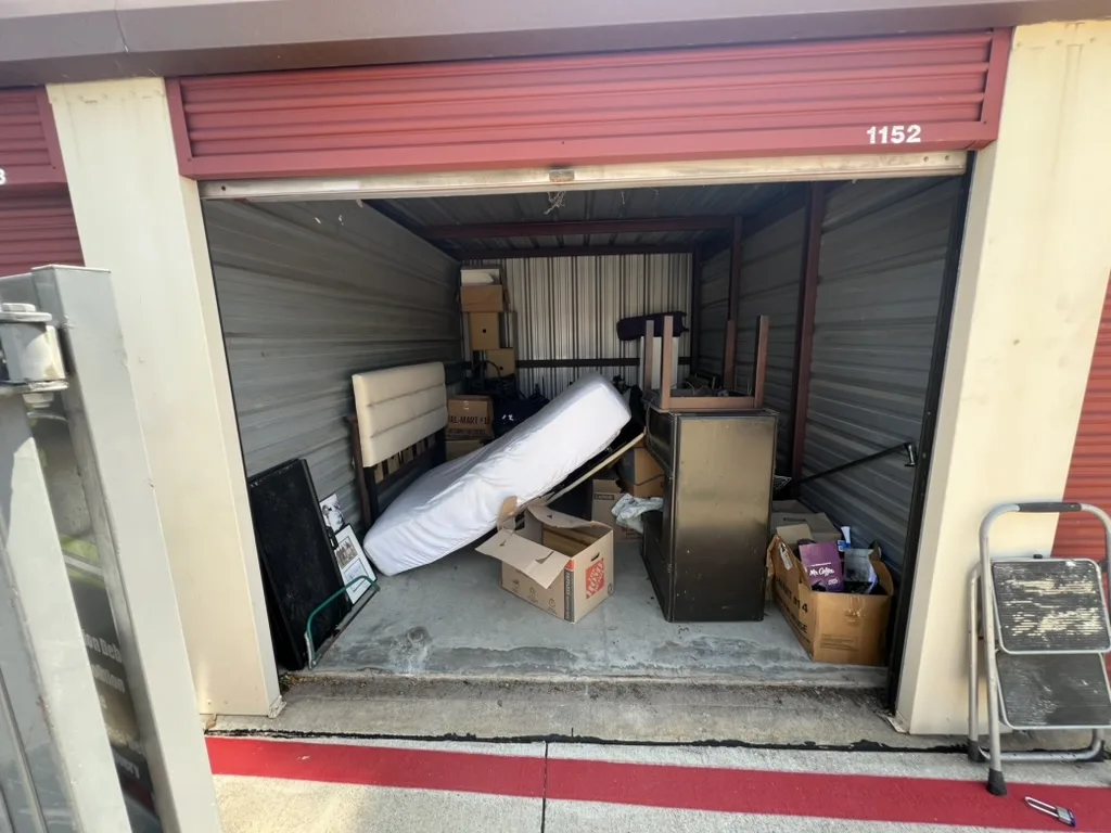 Storage unit with a mattress, dresser, and boxes before a Kick It cleanout
