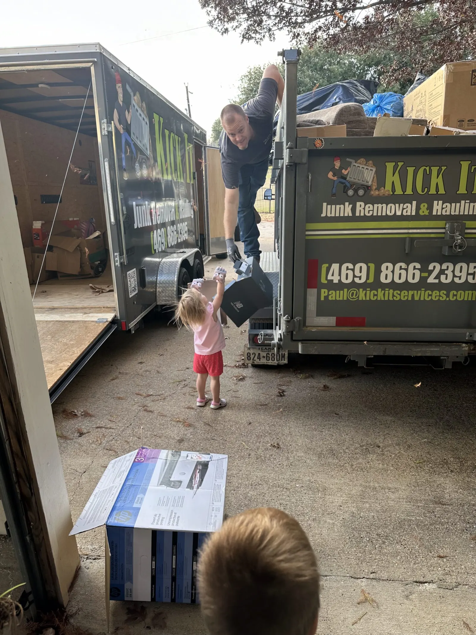 Kick It kids helping load boxes into the Kick It dump trailer