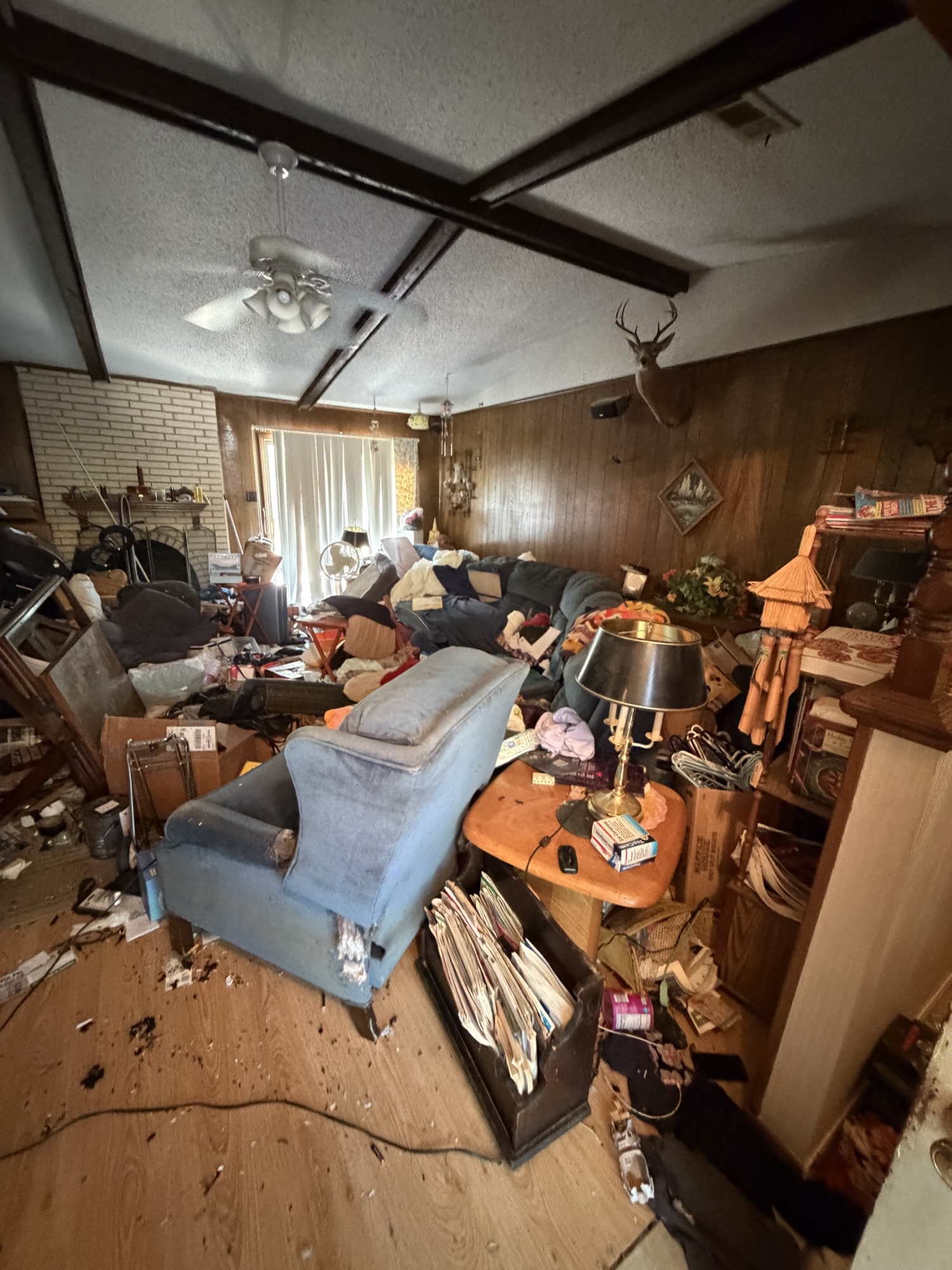 The same living room partway through the cleanout, with floor space opening up