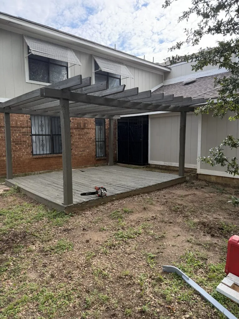 Large wooden pergola in a Dallas backyard before removal