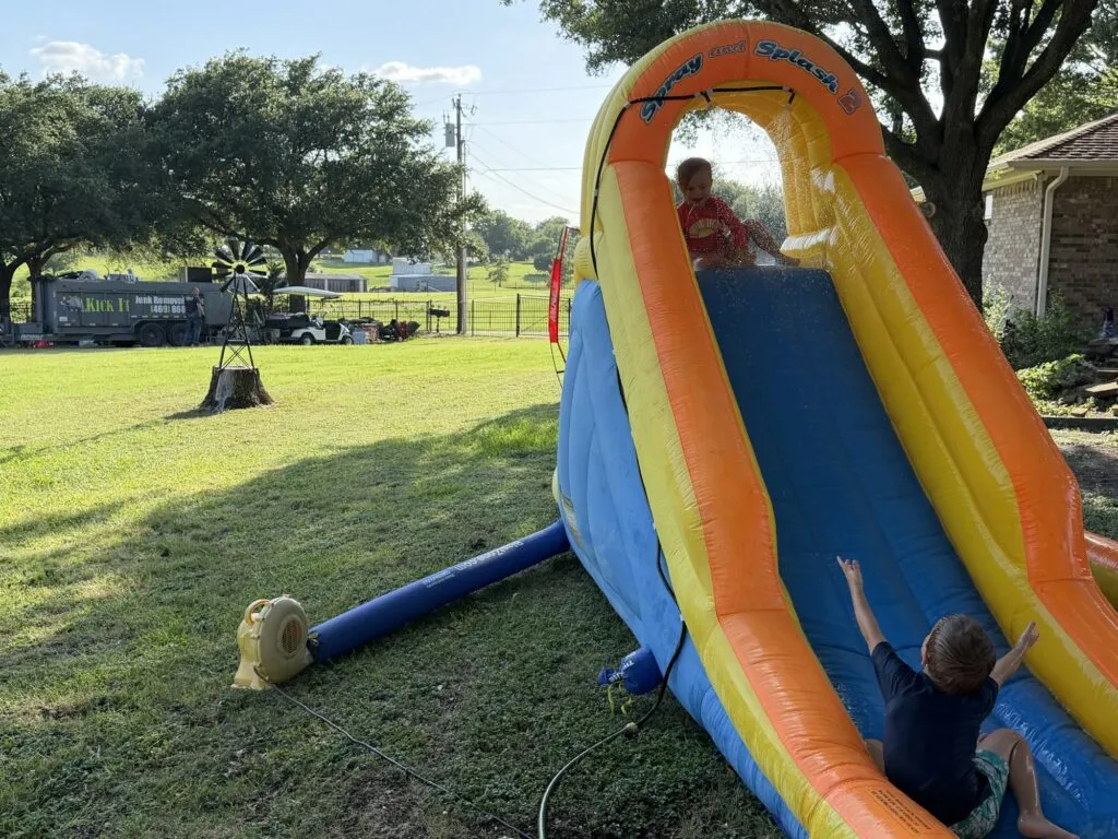 Kids on a water slide while Paul unloads the Kick It trailer