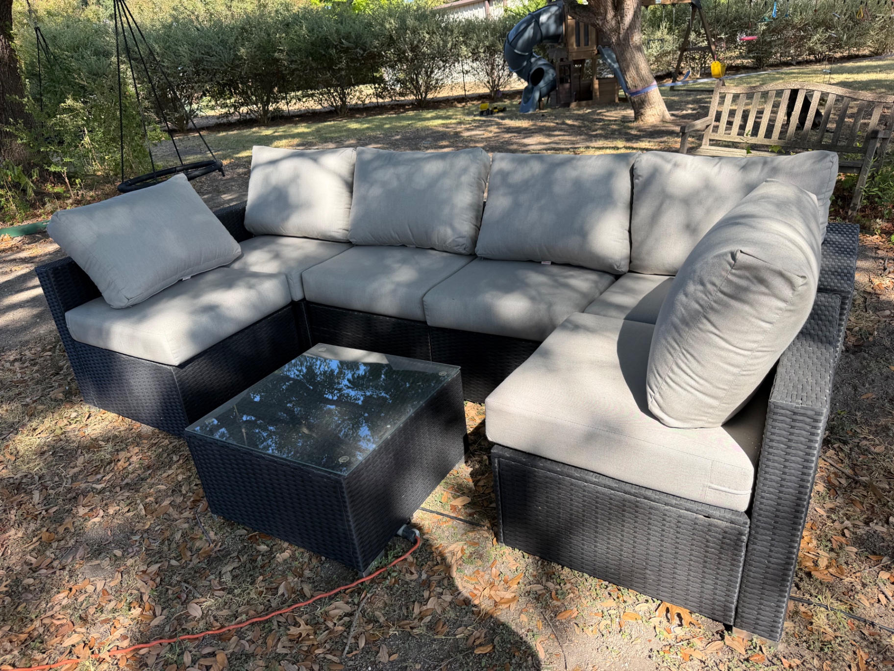 Outdoor wicker patio sectional in a backyard before removal