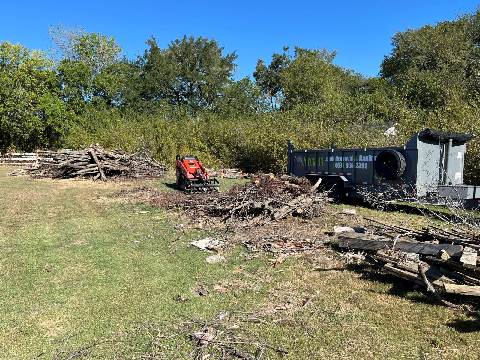 Brush and yard debris being cleared with a skid steer