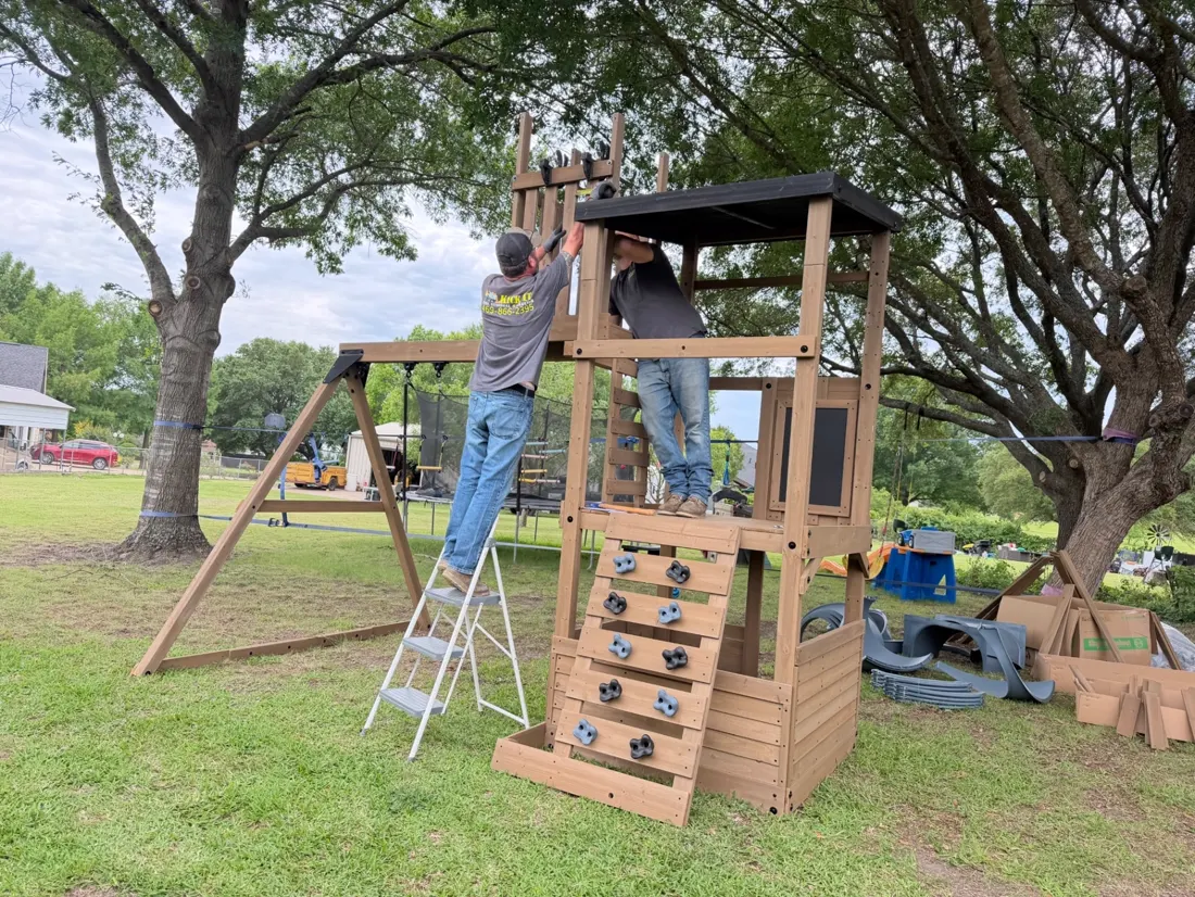 Kick It crew assembling the wooden playset tower and swing beam